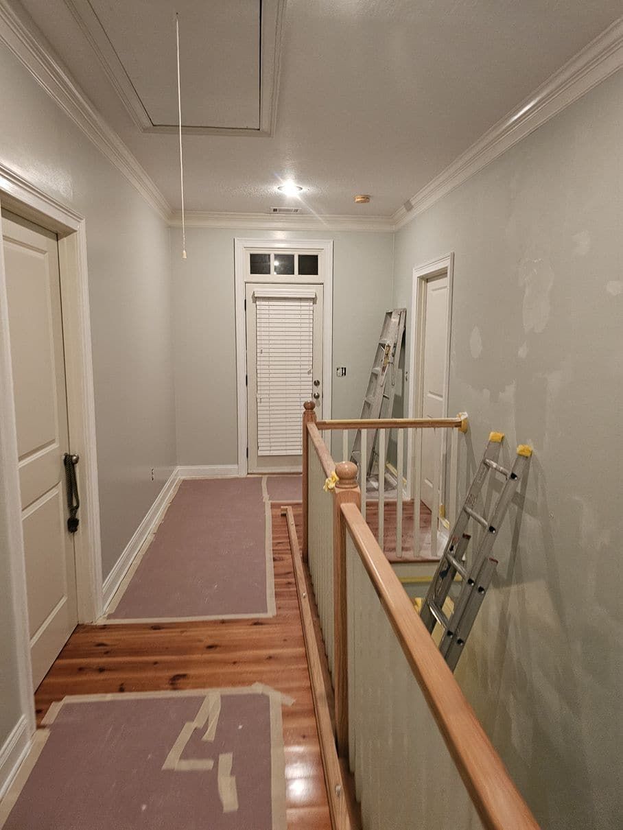 A hallway with a ladder on the railing and the number 4 on the floor
