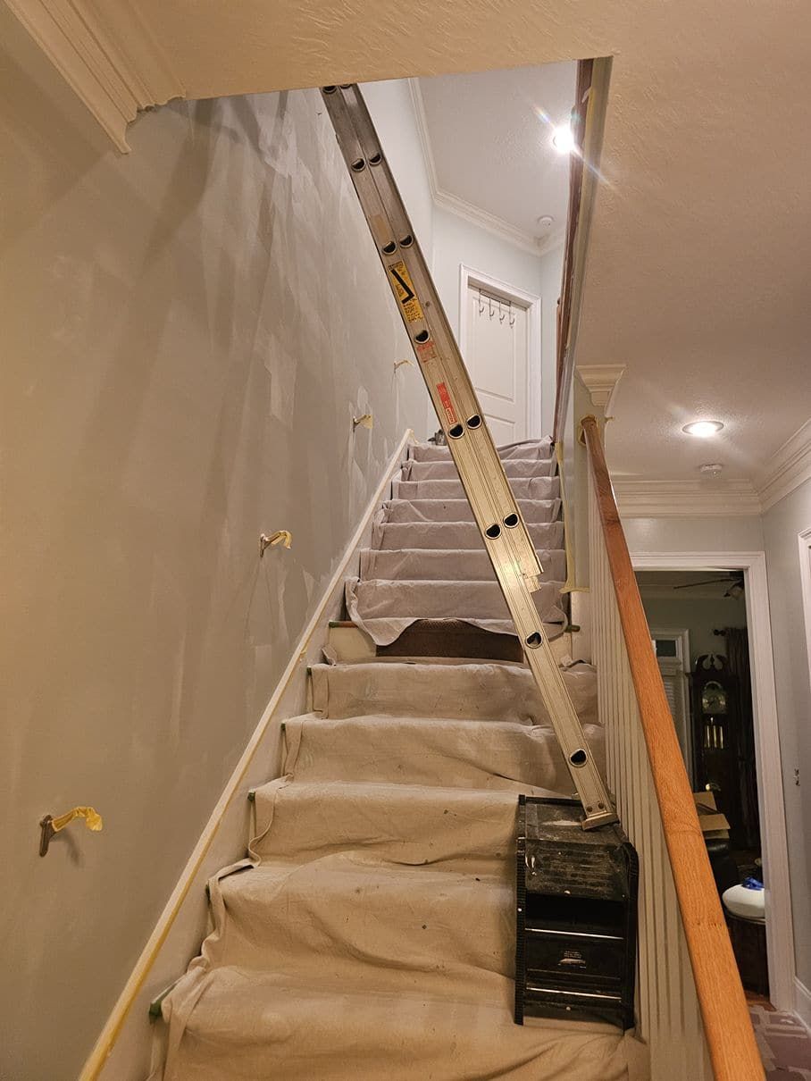 A ladder is leaning against a wall on a set of stairs.