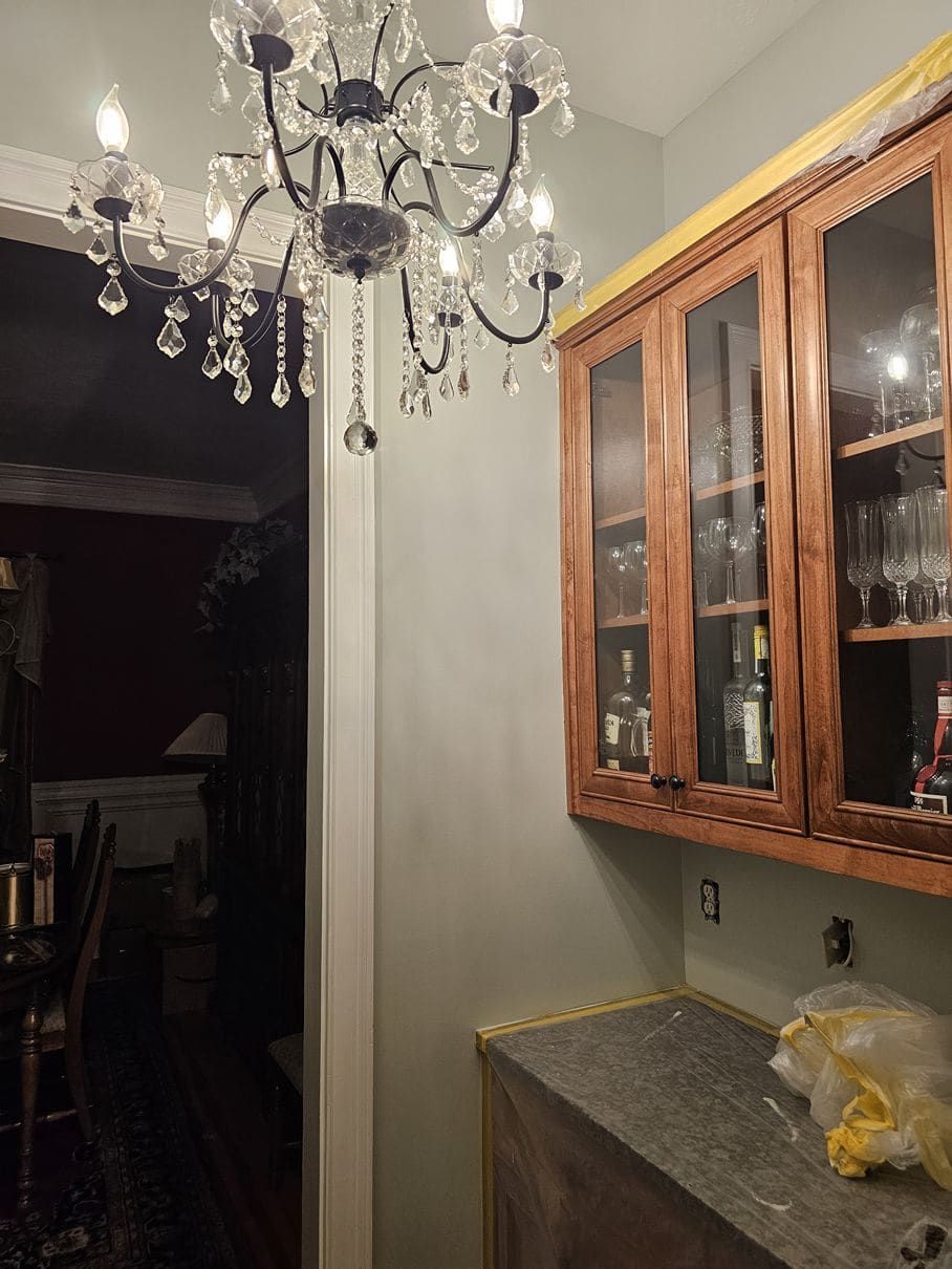 A kitchen with wooden cabinets and a chandelier hanging from the ceiling.