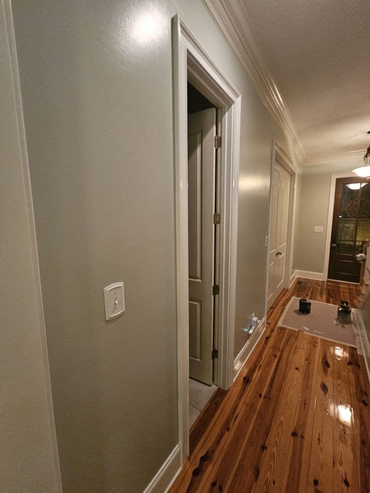 A hallway with hardwood floors and gray walls