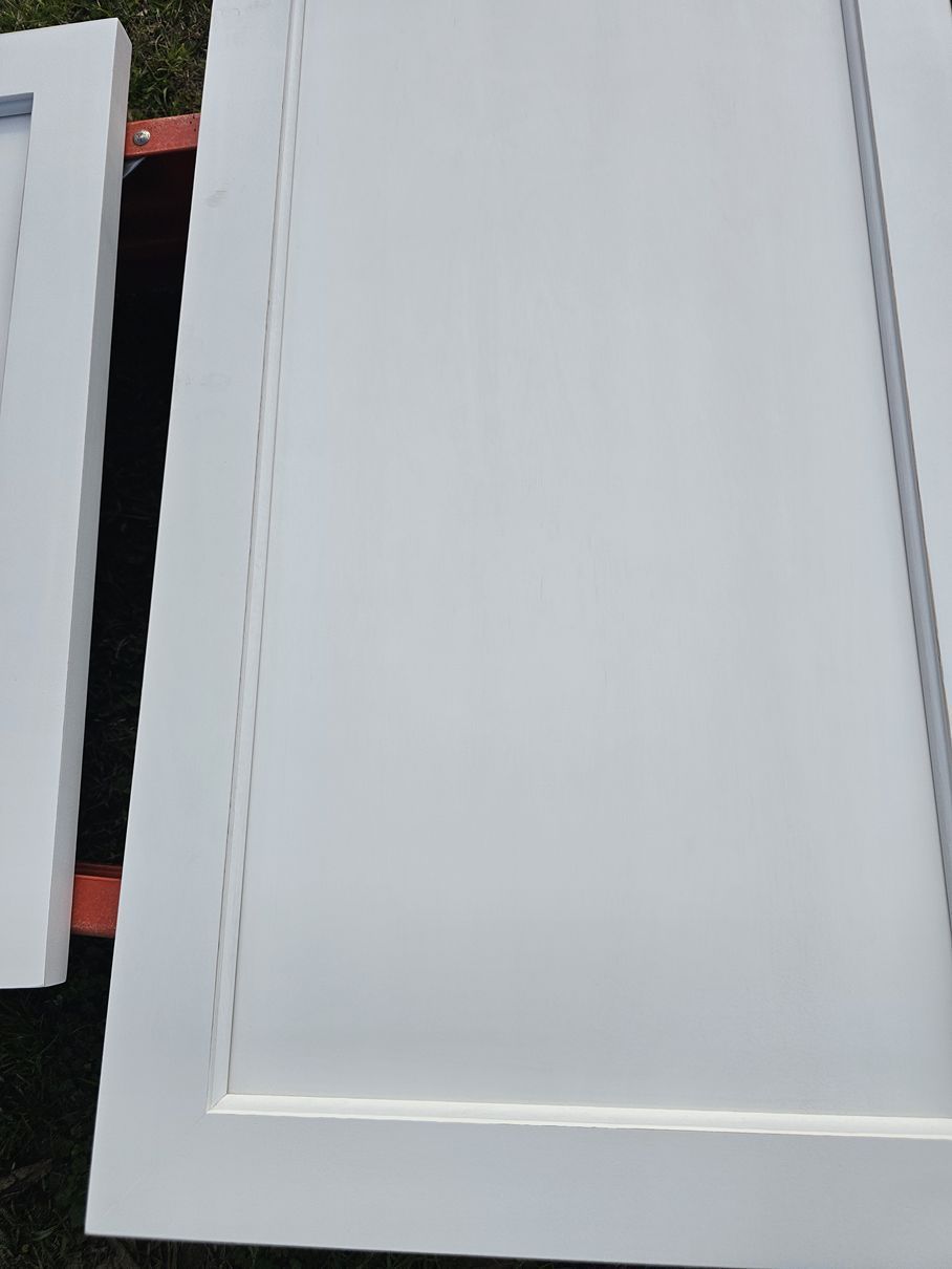 A close up of a white cabinet door on a table.