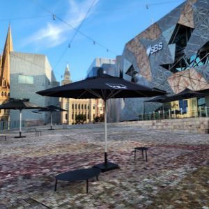 Picture of Fed Square in Melbourne which is a large colourful paved open space, with tables, chairs and a building in the background.