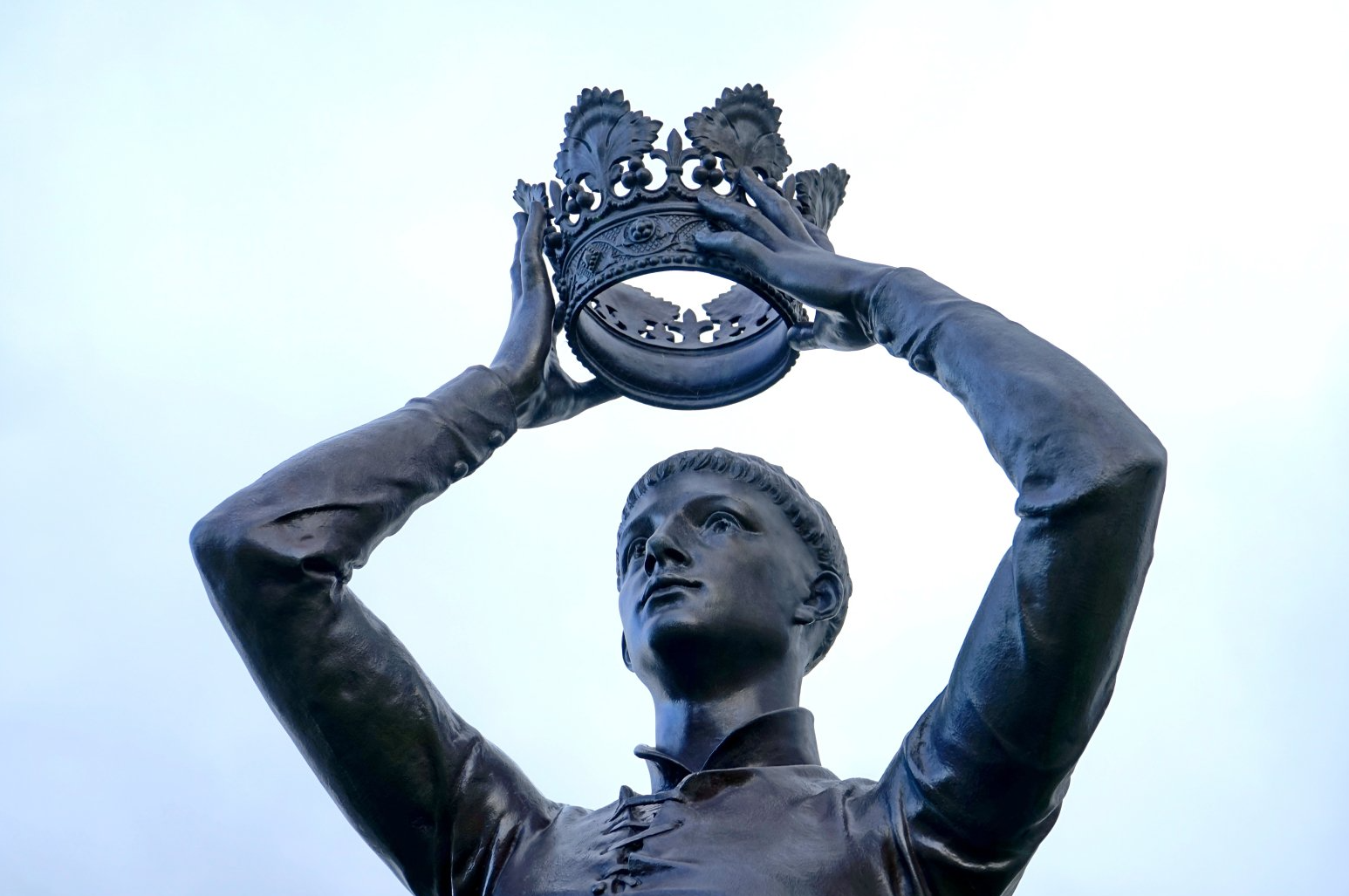 male statue holding crown