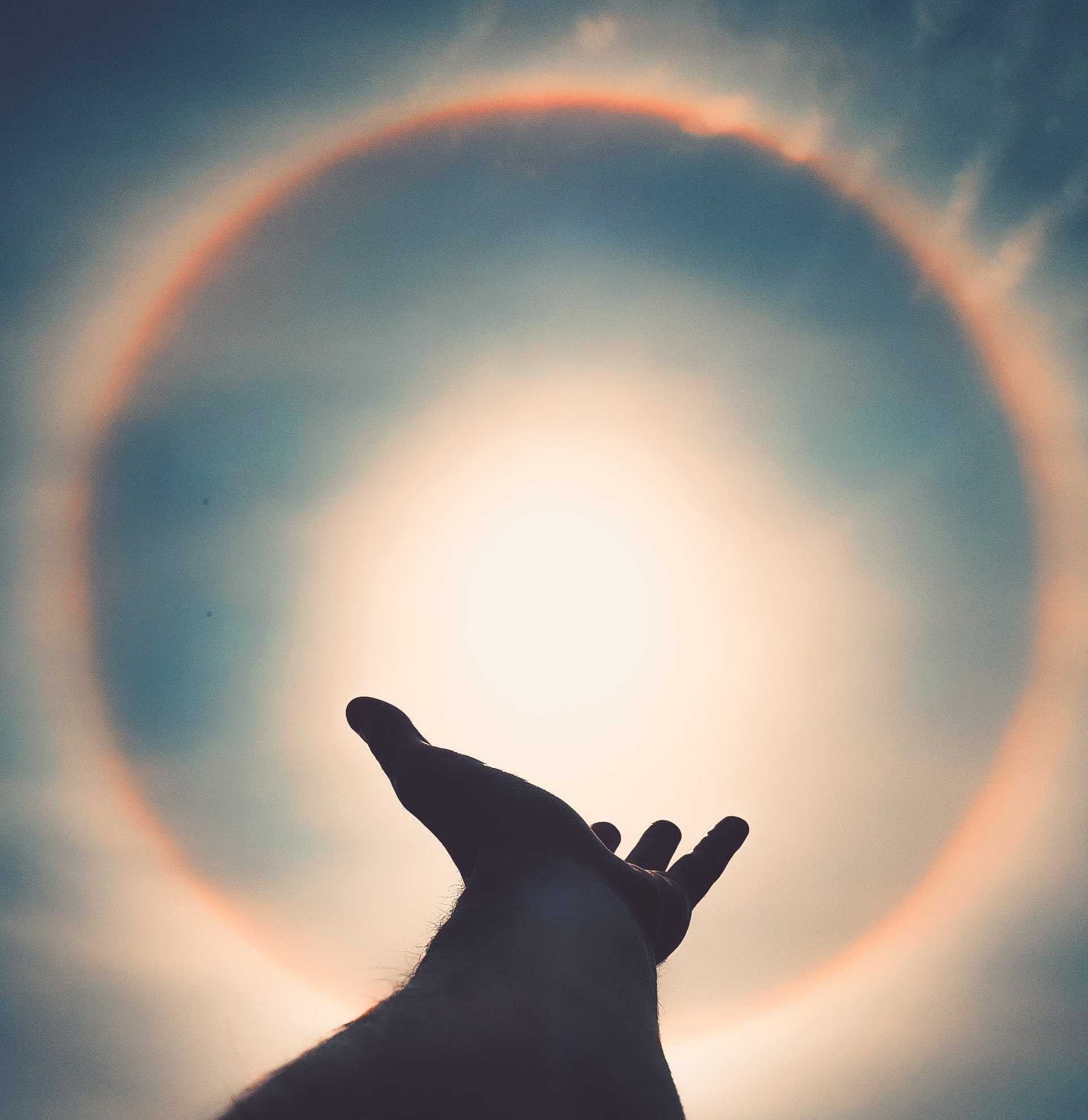 dark hands reaching upward sun light circle
