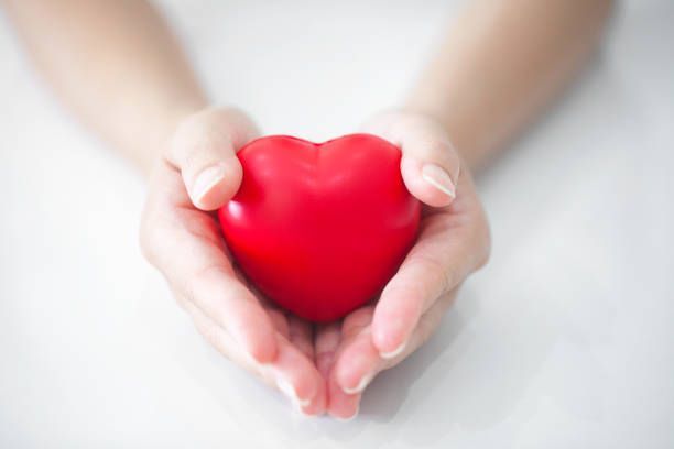 Woman holding heart, showcasing heart disease awareness, representing heart scan concept.