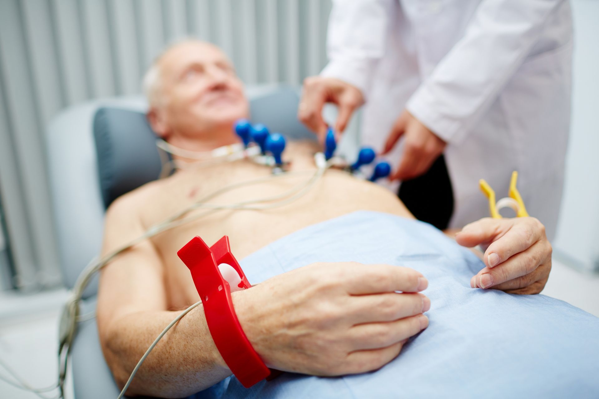 A patient with special equipment around his wrists before having an EKG.