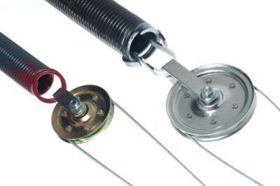 Two garage door springs with pulleys and cables against a white background.