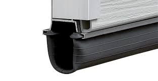 Black rubber garage door bottom seal, attached to door, with a metal retainer.