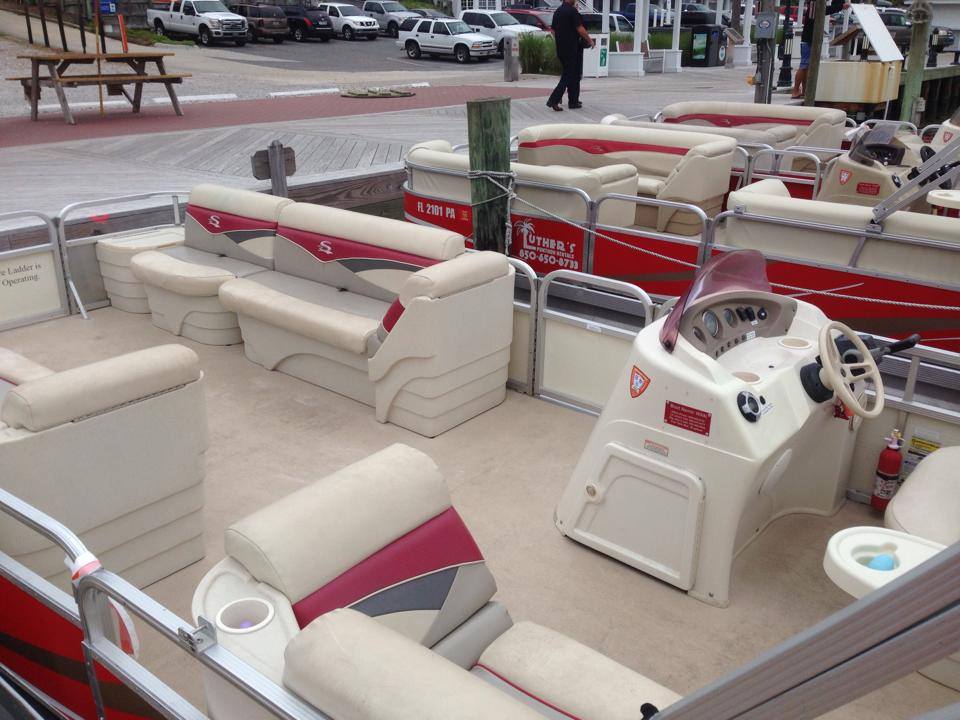 Interior seating and steering wheel of a pontoon boat rental from Luther's Rentals