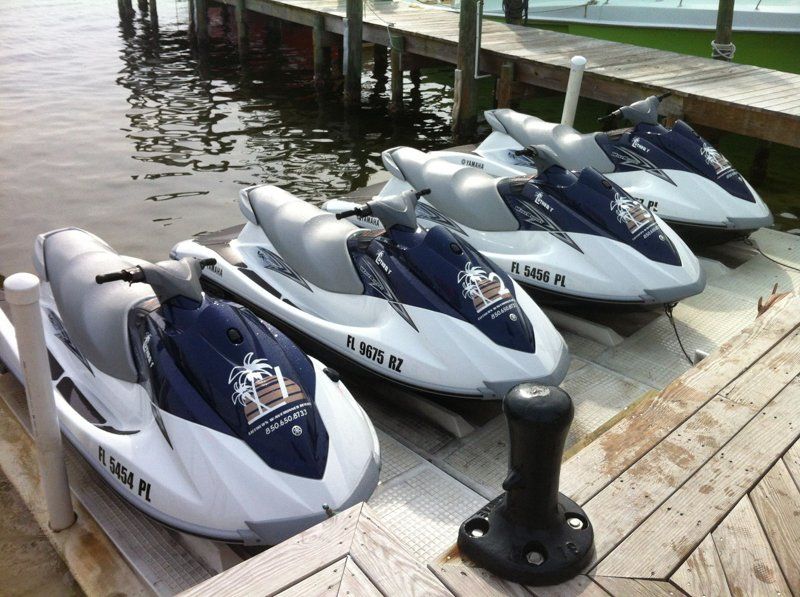 4 blue and white jet skis docked at Luther's WaveRunner Rentals