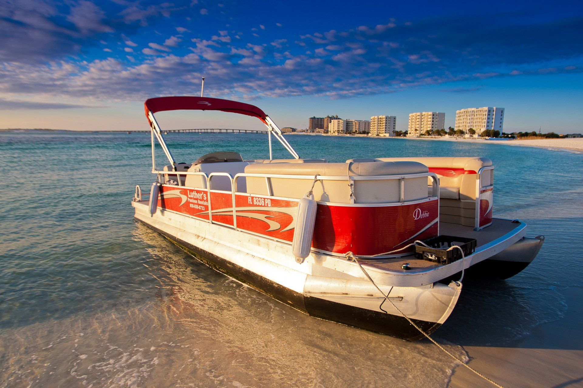 Red pontoon boat anchored on Destin FL beach