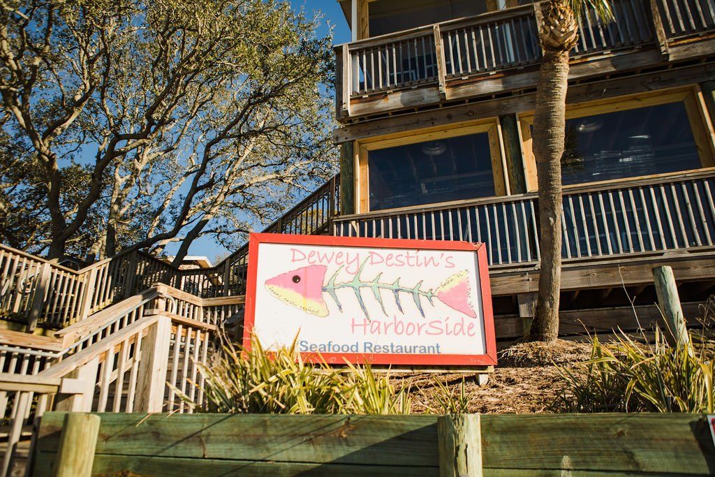 sign of Dewey Destin's Harborside Seafood Restaurant with colorful fish skeleton