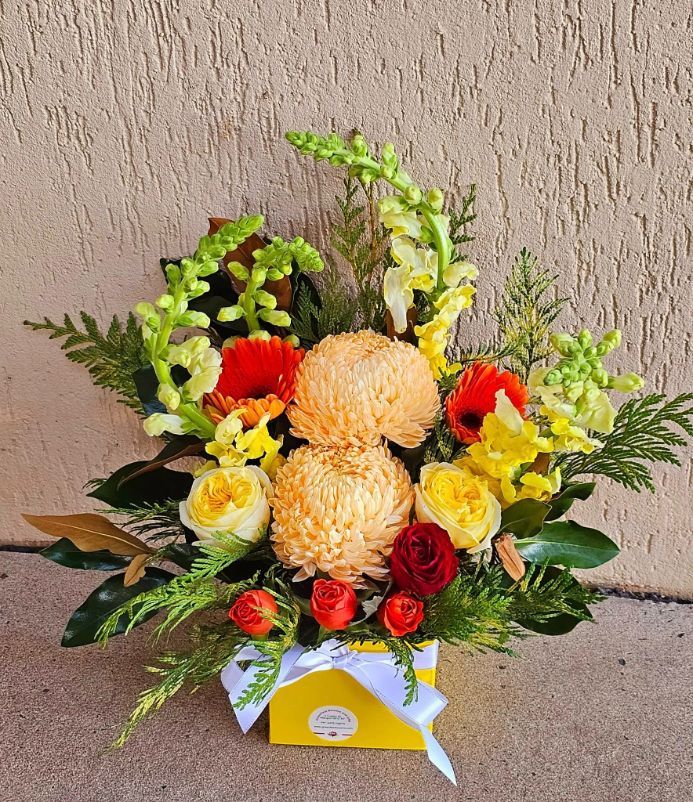 A Yellow Box Filled With Flowers is Sitting on the Ground — Greenfield Blooms and Gifts In Wanguri, NT