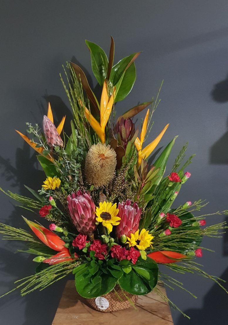 A Large Bouquet of Flowers is Sitting on a Wooden Table — Greenfield Blooms and Gifts In Wanguri, NT