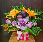 A pink box filled with purple roses and orange lilies — Greenfield Blooms and Gifts In Wanguri, NT