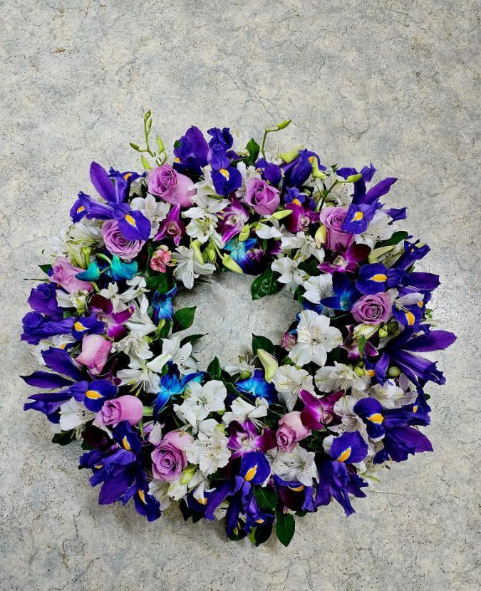 A Wreath of Purple and White Flowers is Sitting on a Table — Greenfield Blooms and Gifts In Wanguri, NT