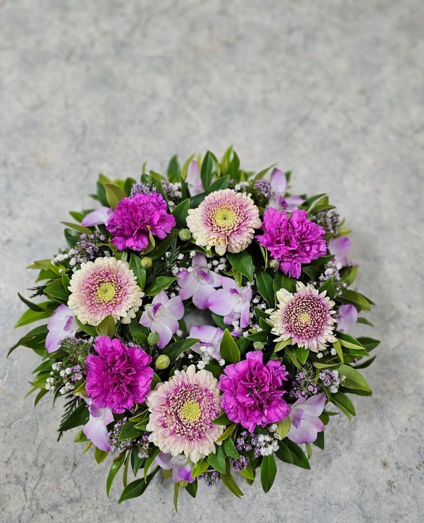 A Wreath of Purple and White Flowers is Sitting on a Table — Greenfield Blooms and Gifts In Wanguri, NT