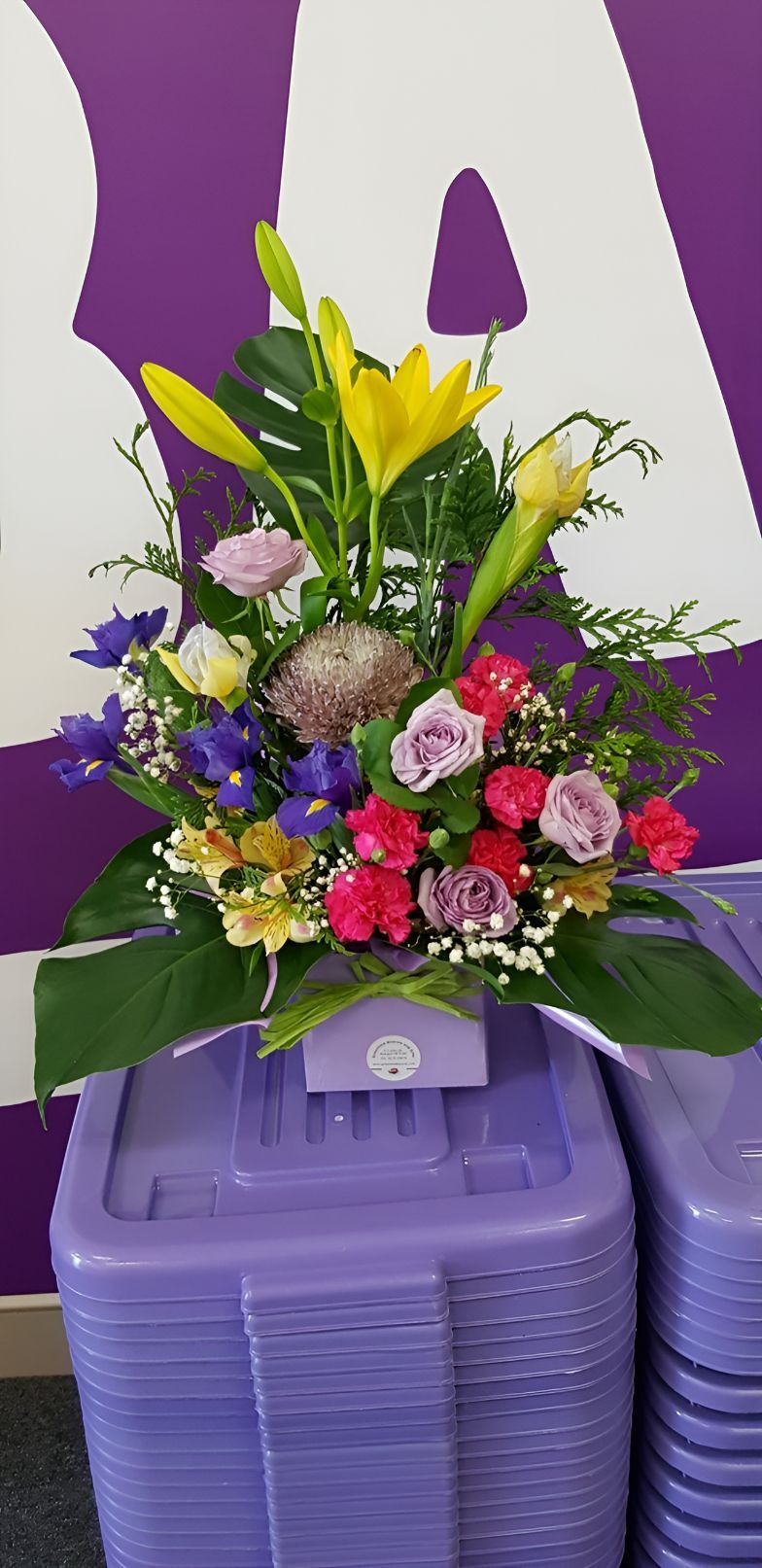 A Bouquet of Flowers is Sitting on Top of a Purple Bin — Greenfield Blooms and Gifts In Wanguri, NT