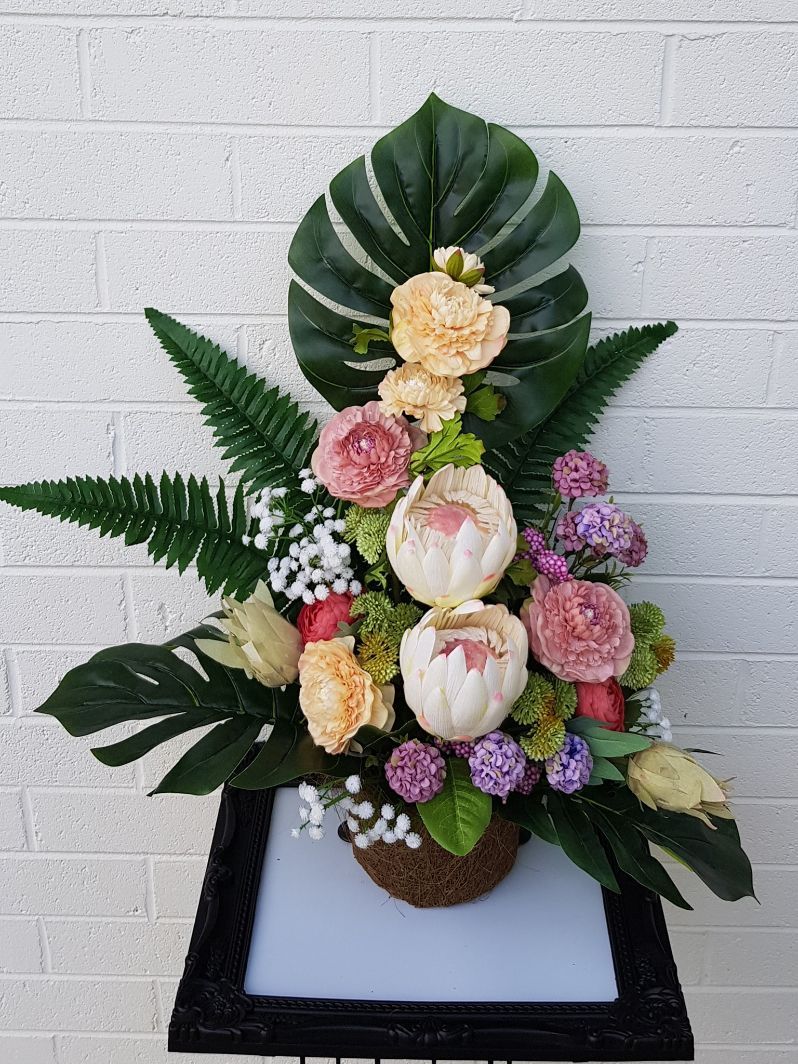 A Bouquet of Flowers is Sitting on a Table in Front of a Brick Wall — Greenfield Blooms and Gifts In Wanguri, NT