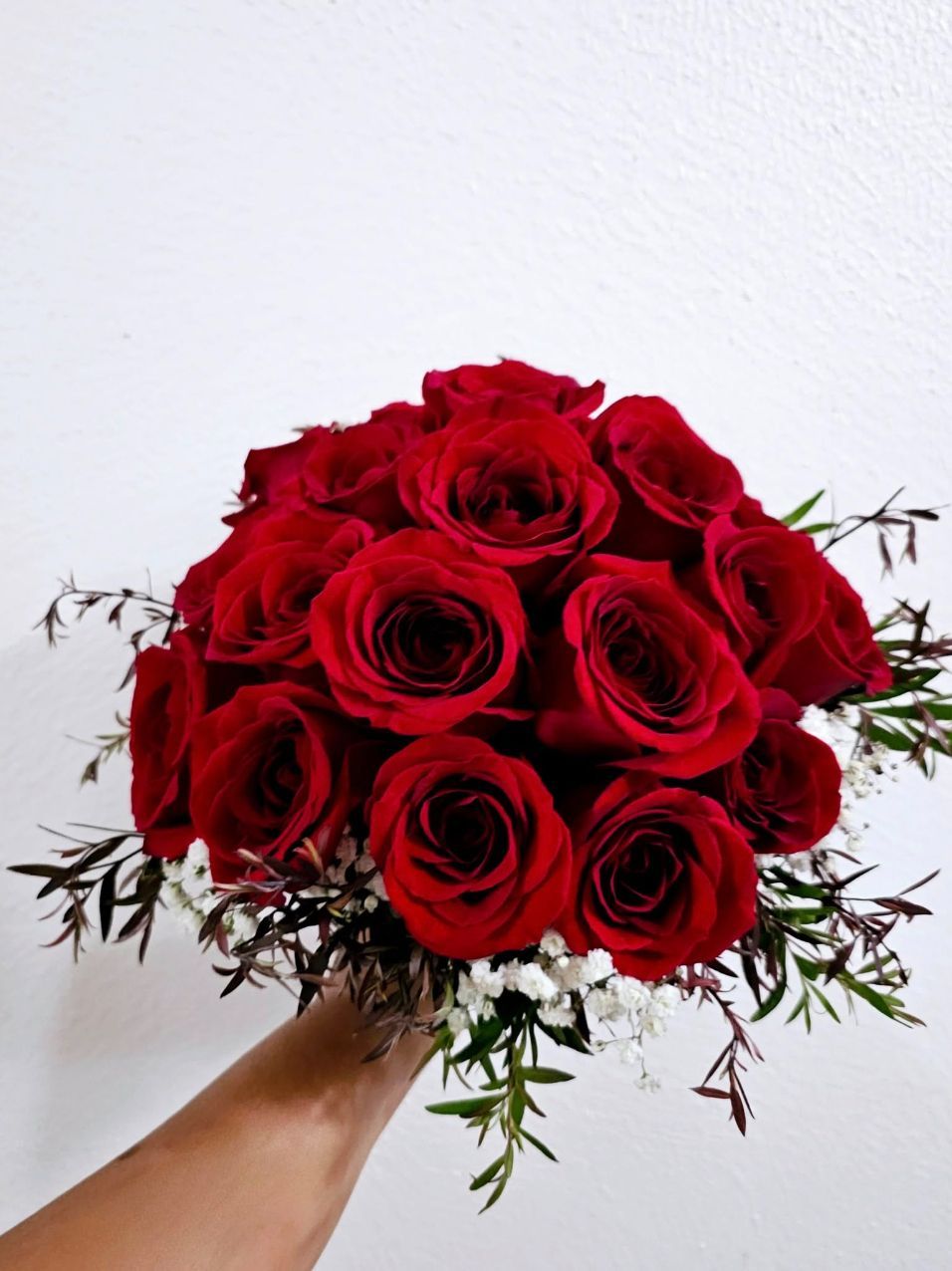 A Person is Holding a Bouquet of Red Roses — Greenfield Blooms and Gifts In Wanguri, NT