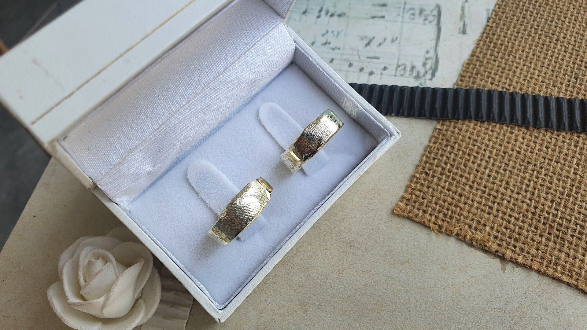 זוג טבעות נישואין יושבות בקופסה לבנה.