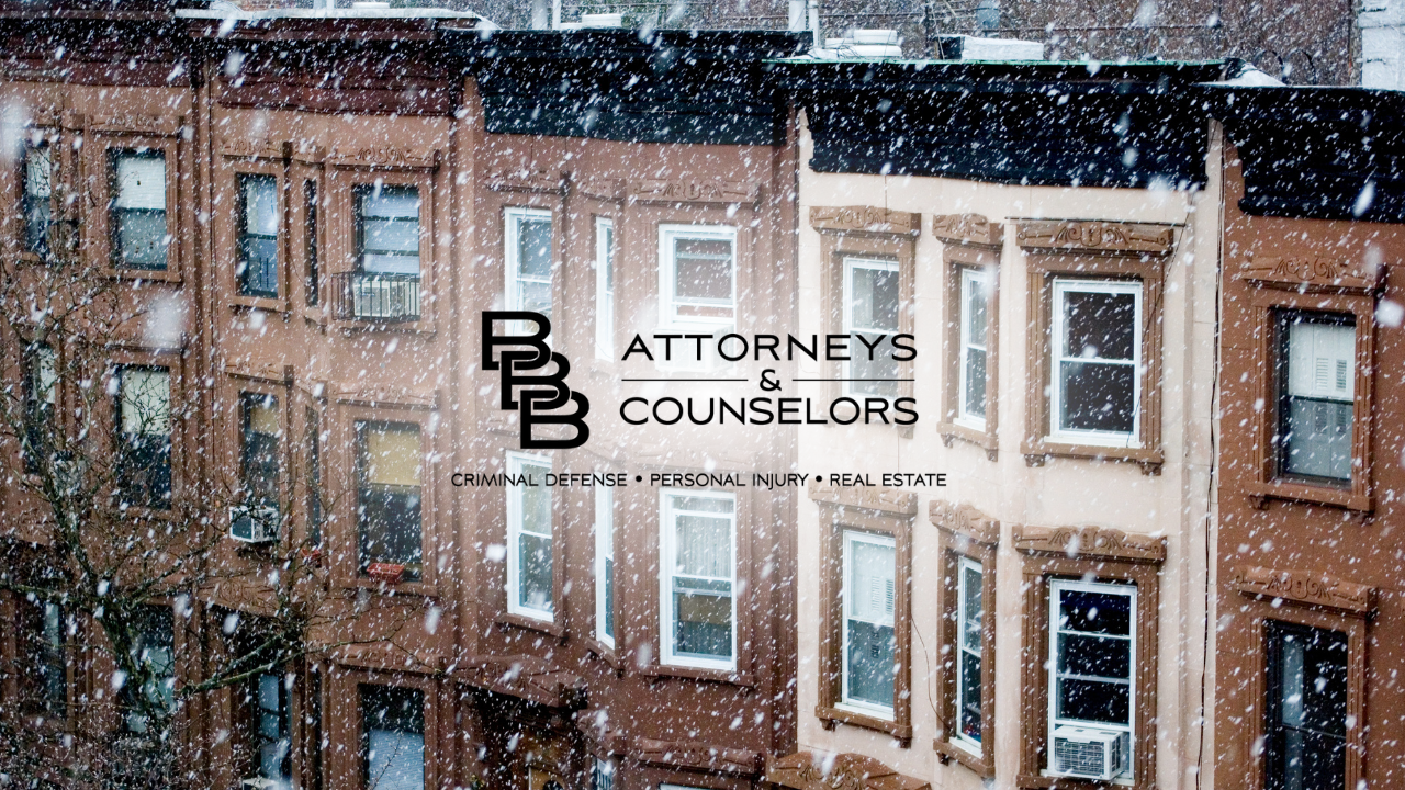 Snowy brick buildings with a centered “Attorneys & Counselors” sign.