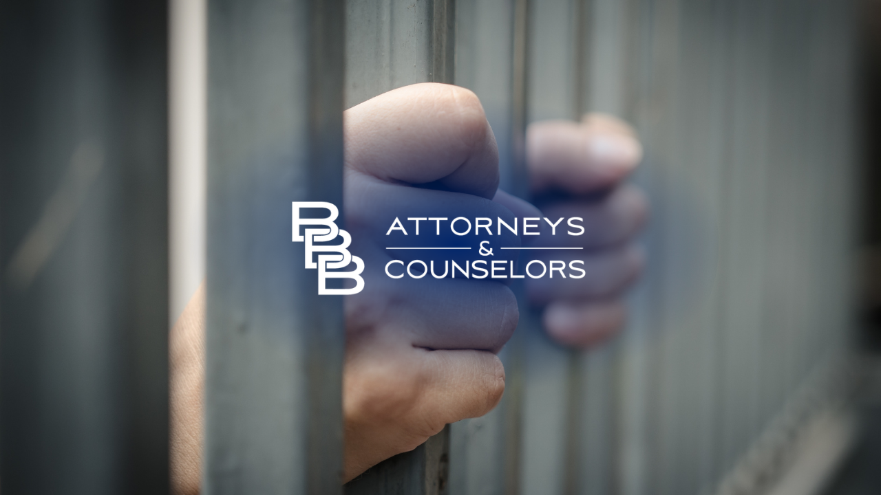 Hand holding bars with “Attorneys & Counselors” logo in the center