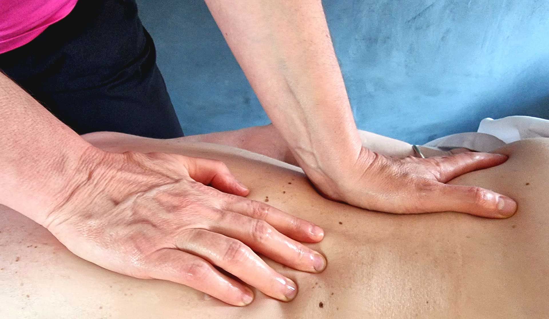 A woman is giving a massage to a man 's back.