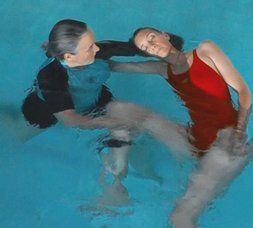 A man and a woman are swimming in a pool.
