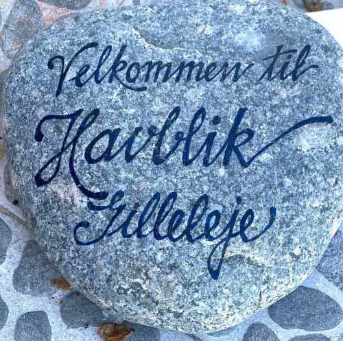 A large rock with the words velkommen til havblik filleleje written on it