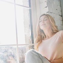 Window Coverings — Woman Sitting Next to a Window in Placenta, CA
