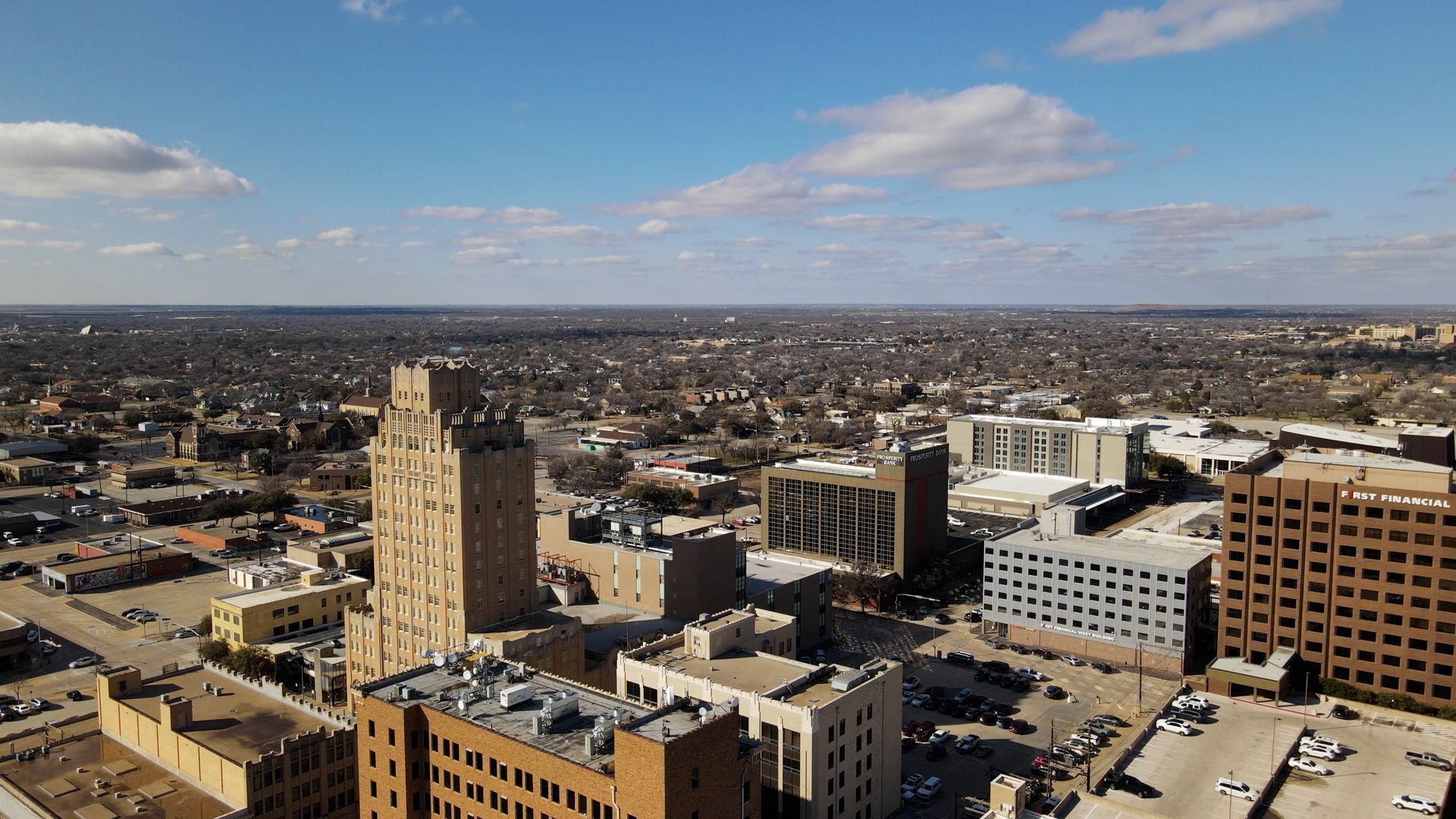 An aerial view of a city with lots of buildings and a parking lot.