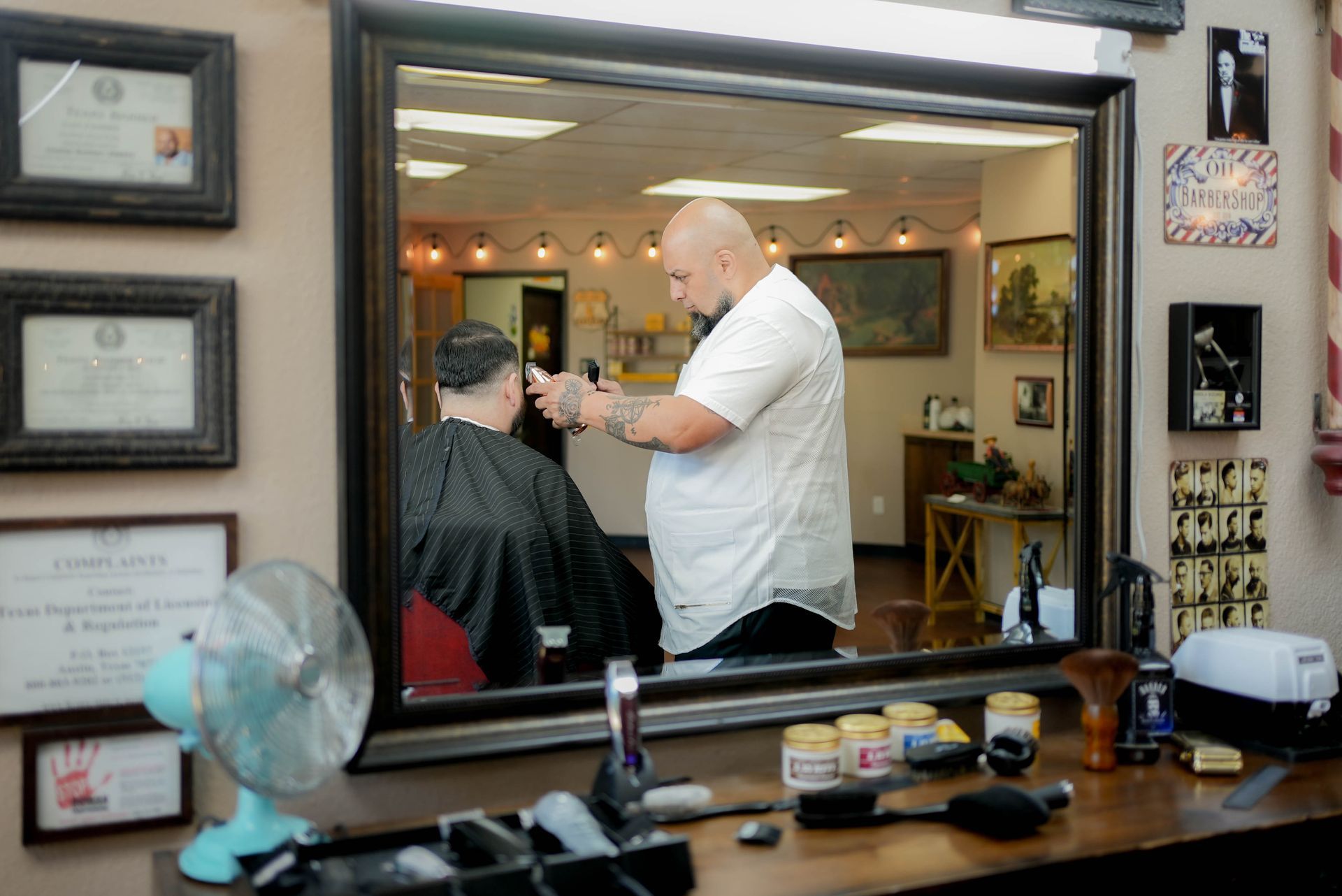 A man is getting his hair cut by a barber in a barber shop.