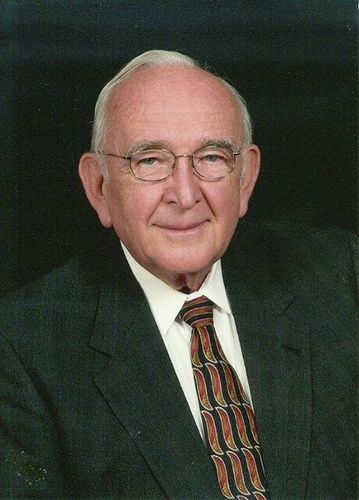 A man in a suit and tie is smiling for the camera