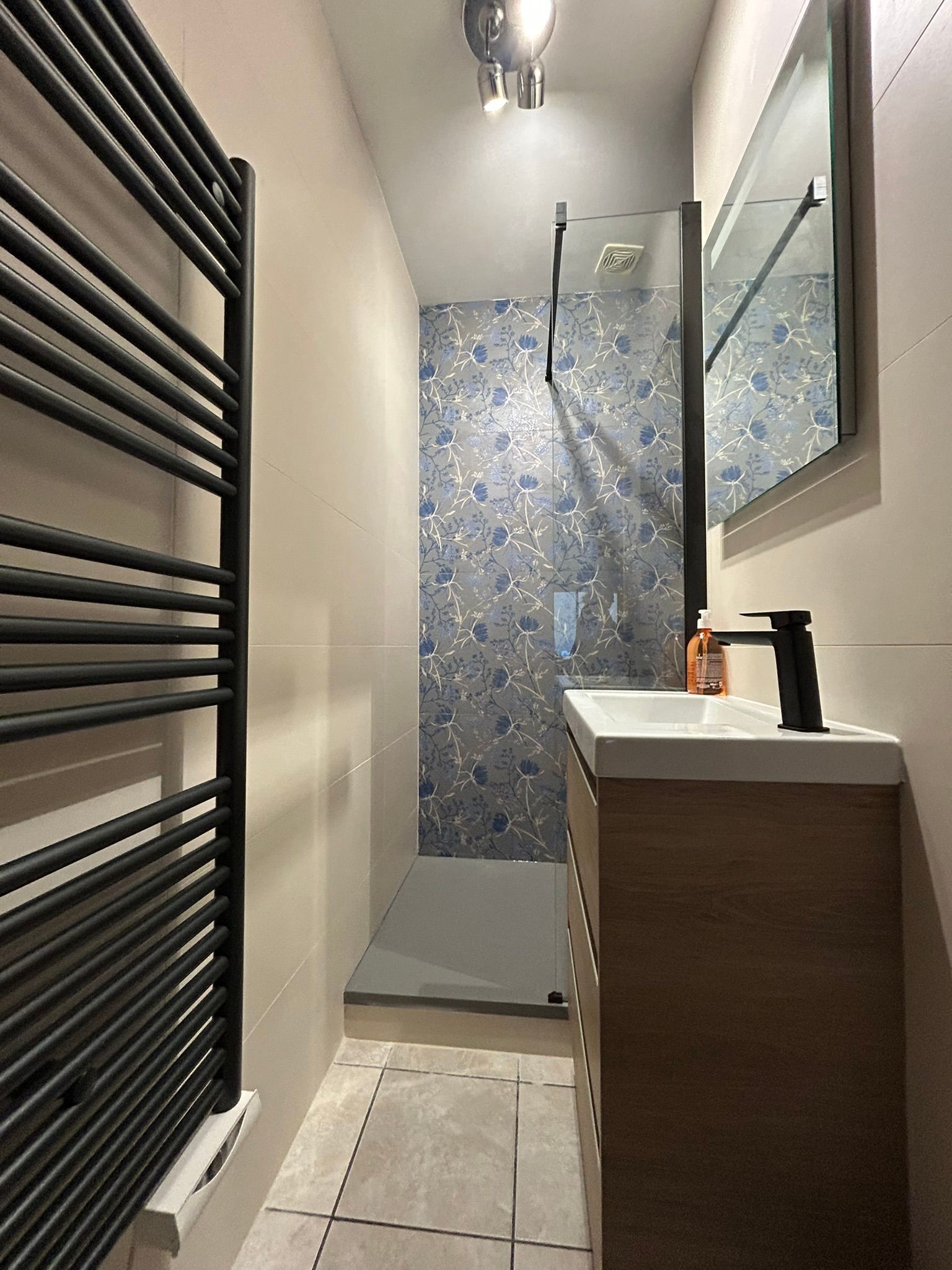 Salle de bain avec douche lavabo et radiateur seche serviette 