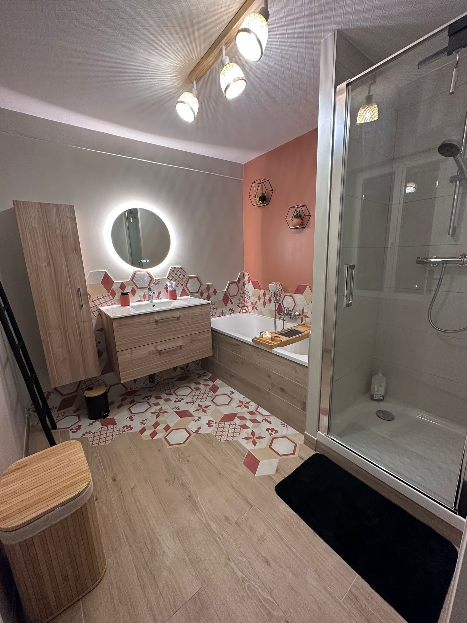 Salle de bain au Havre avec carrelage haut de gamme, miroir, lavabo sur meuble, baignoire et cabine de douche