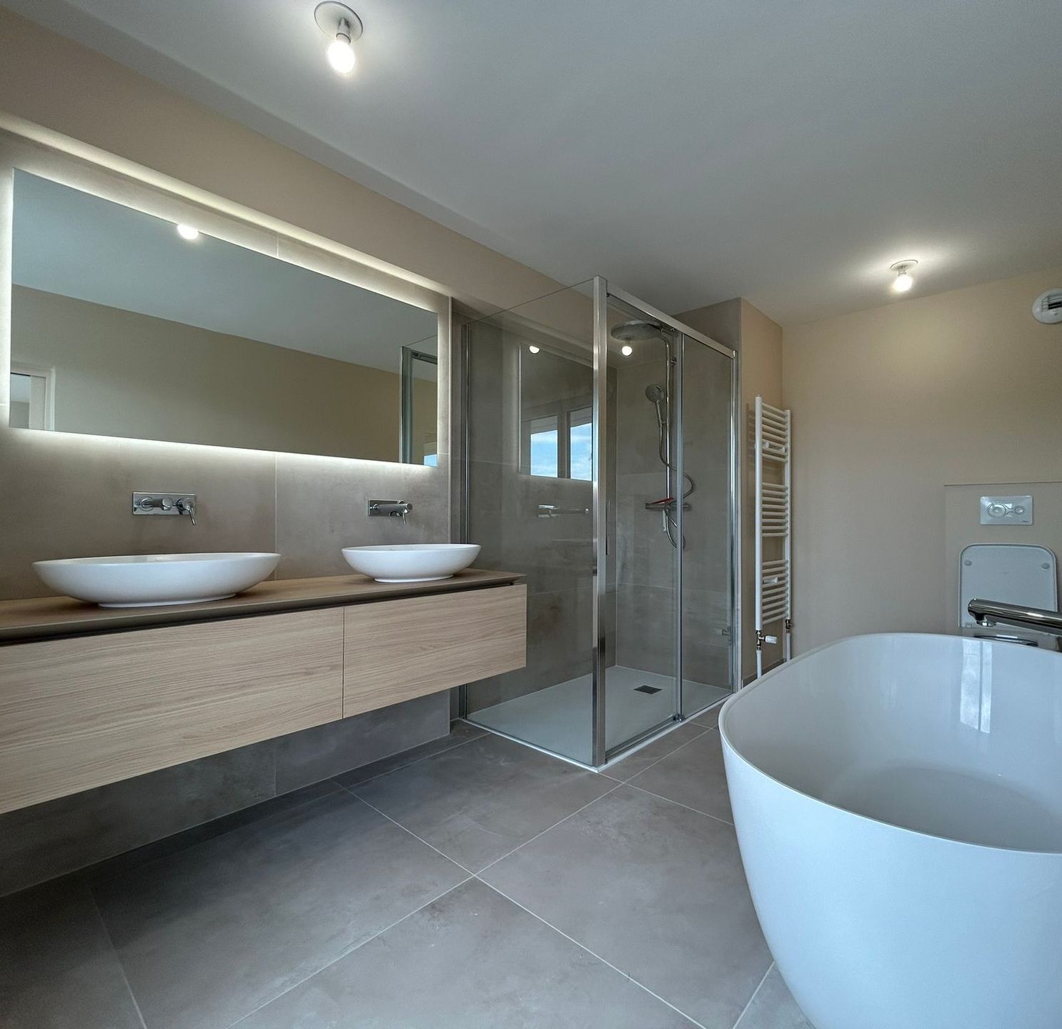 Création unique, salle de bain au Havre avec double vasque, baignoire et cabine de douche ainsi que miroir haut de gamme.