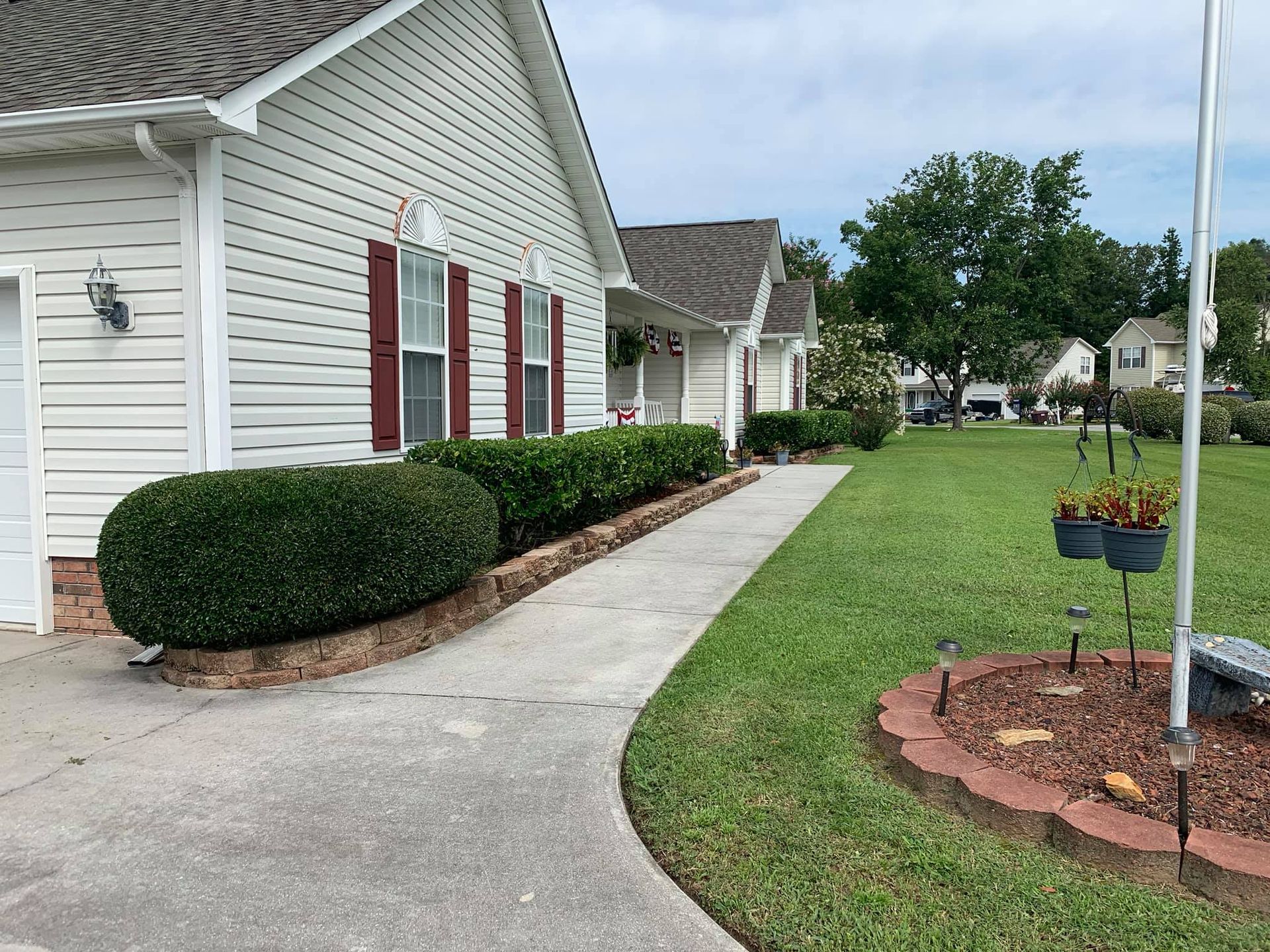 A white house with red shutters and a flag in front of it