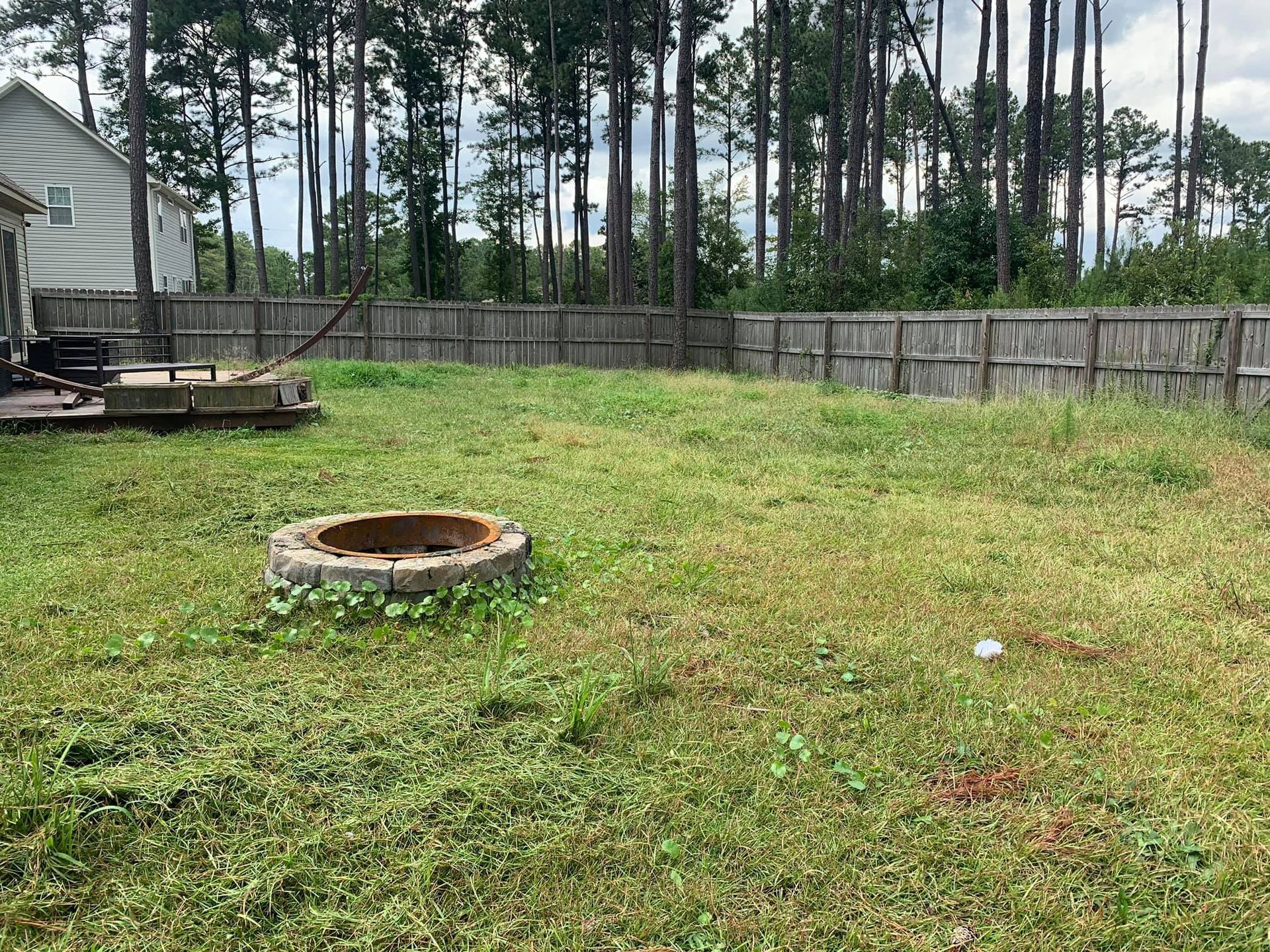 There is a fire pit in the middle of the backyard.