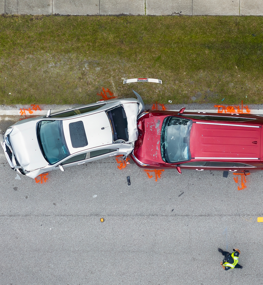 An aerial view of a car accident with a red suv and a white suv