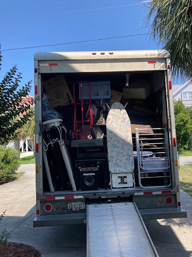 A moving truck is filled with lots of furniture and boxes.