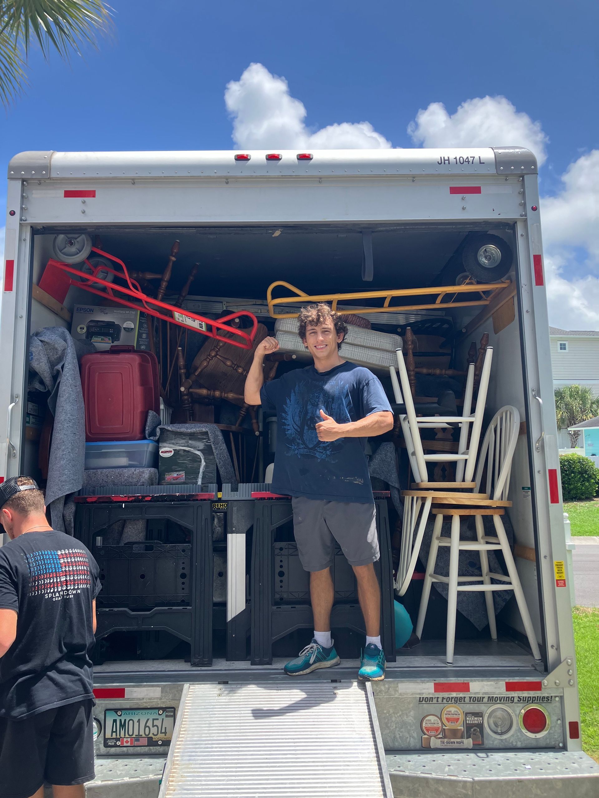A man is standing in the back of a moving truck.