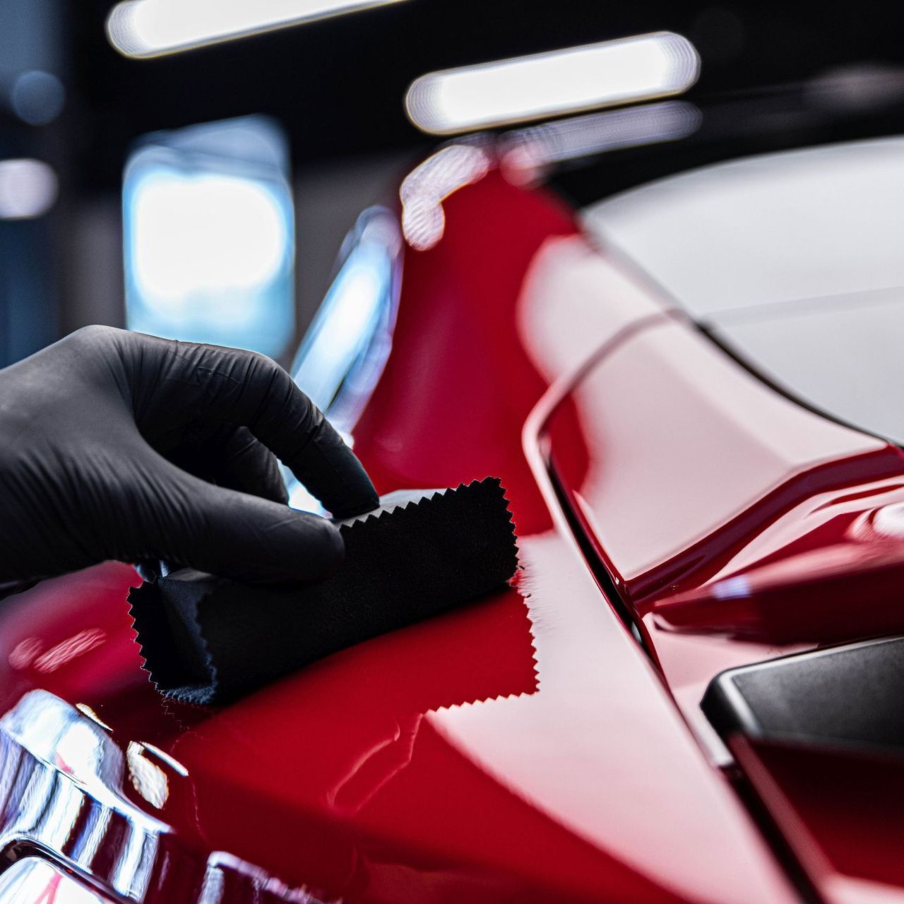 Technician applying ceramic coating to a vehicle's surface, providing long-lasting protection