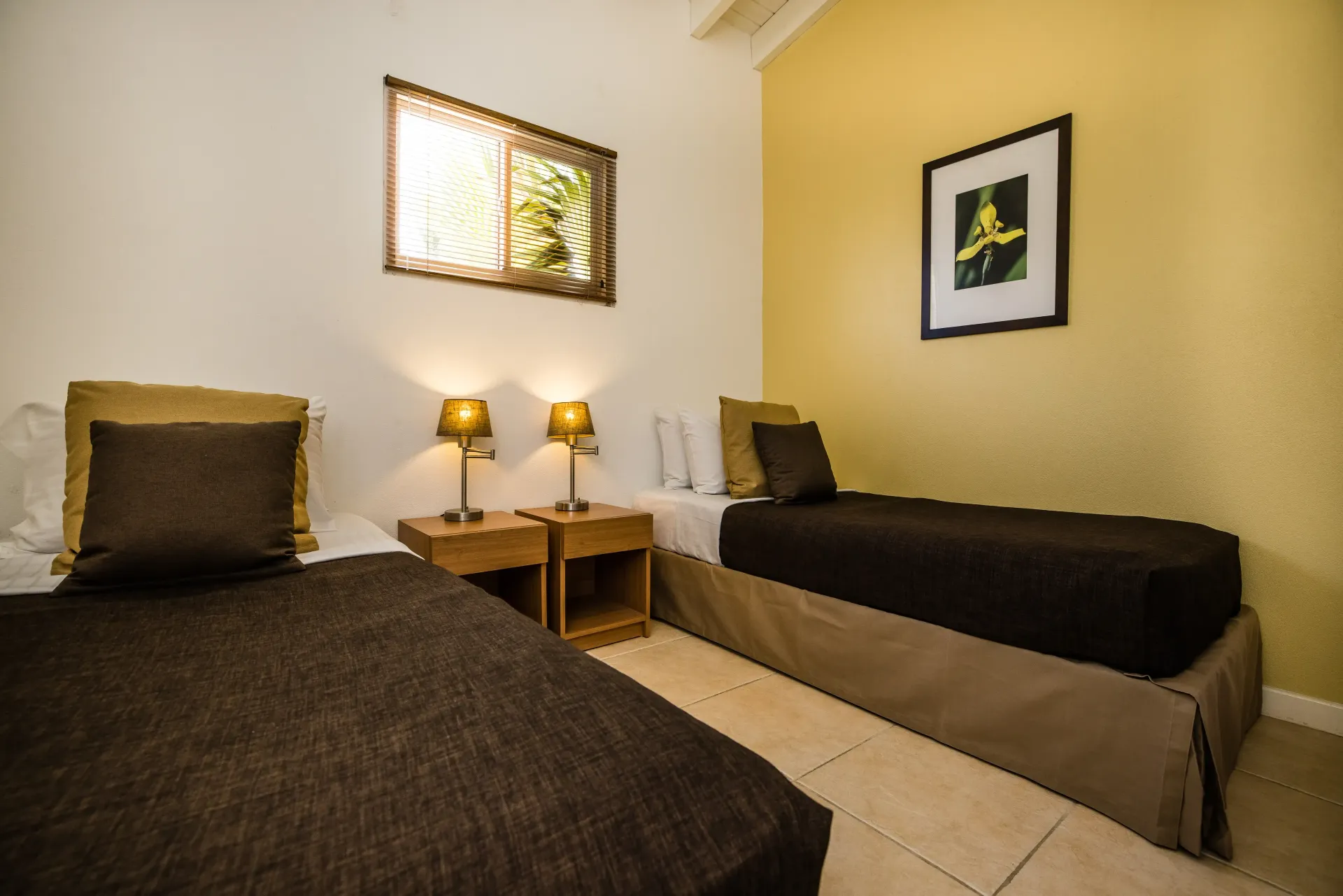 Bedroom with two twin beds, small nightstands, and a framed art piece.