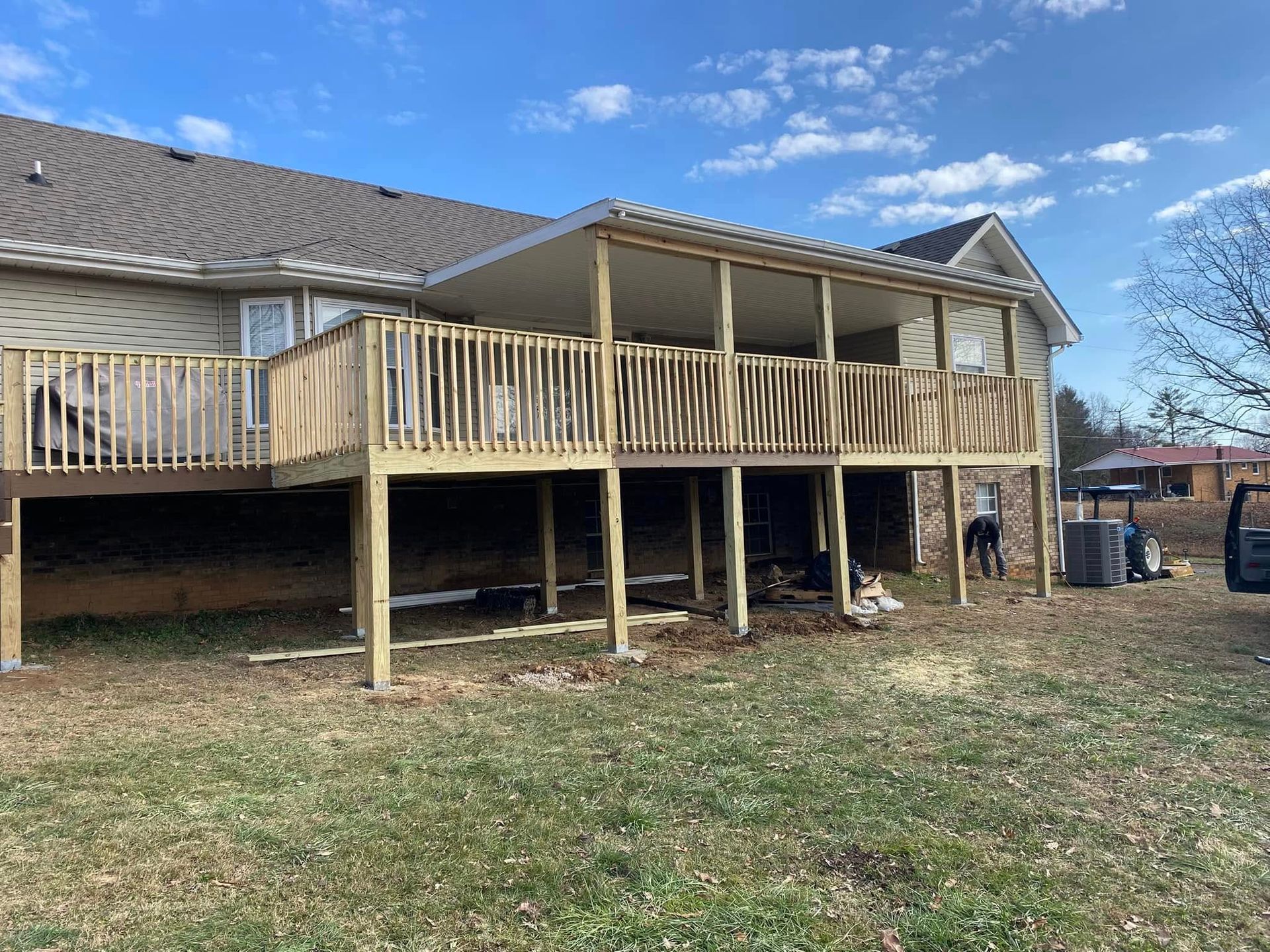 Martinez Construction | A large wooden deck is being built in the backyard of a house.