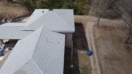 Martinez Construction | An aerial view of a house with a roof that is being installed.