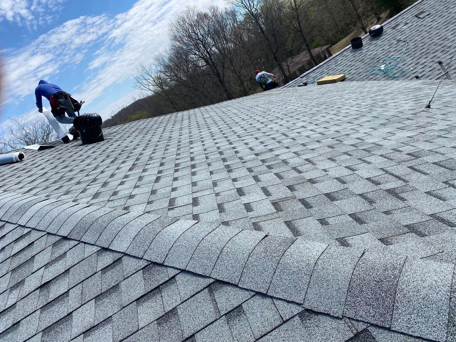 Martinez Construction | A man is working on the roof of a house.