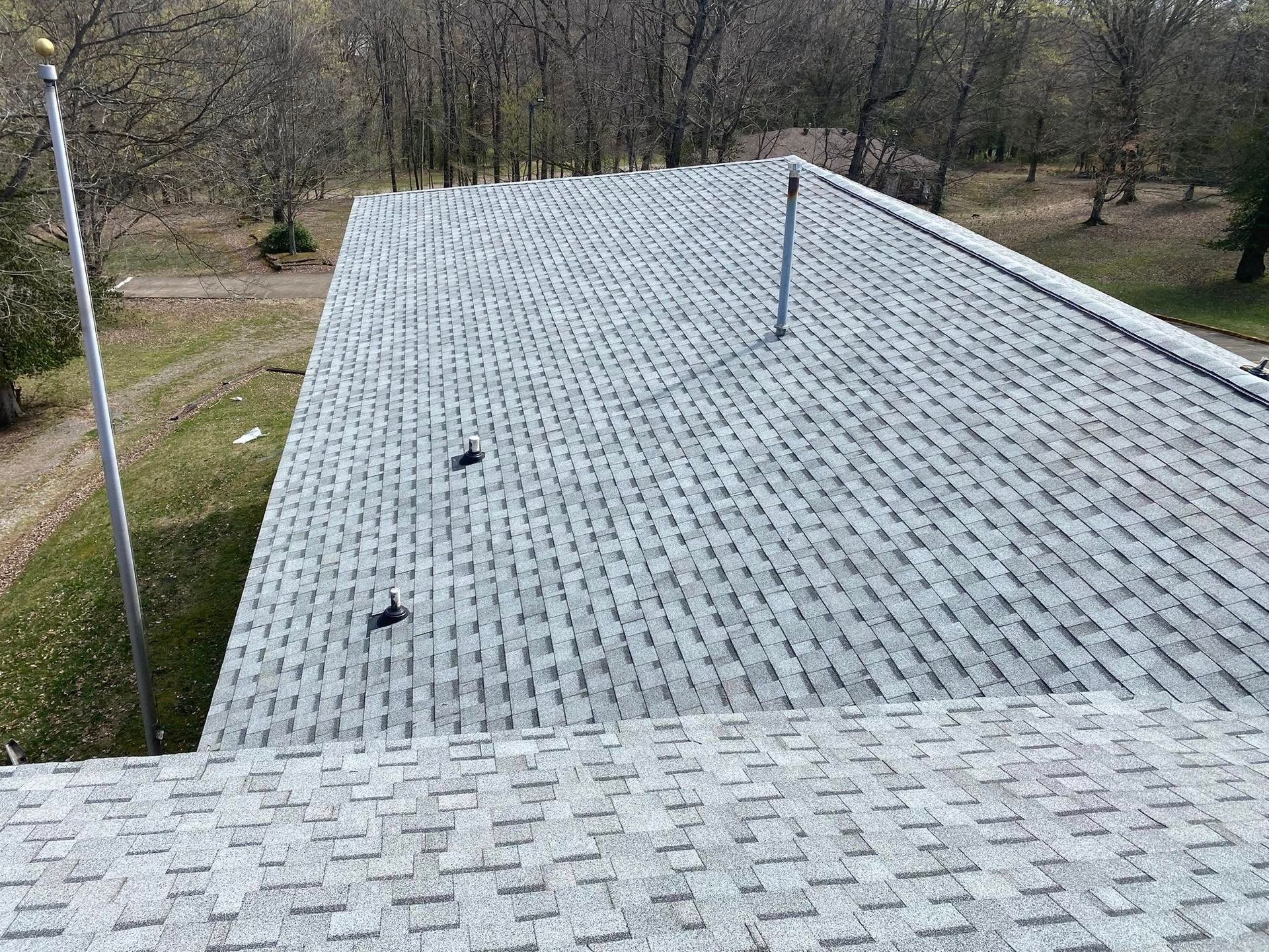 Martinez Construction | A roof with a lot of shingles and a chimney on it.