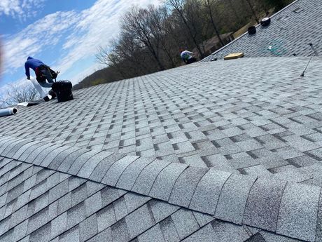Martinez Construction | A man is working on the roof of a house.
