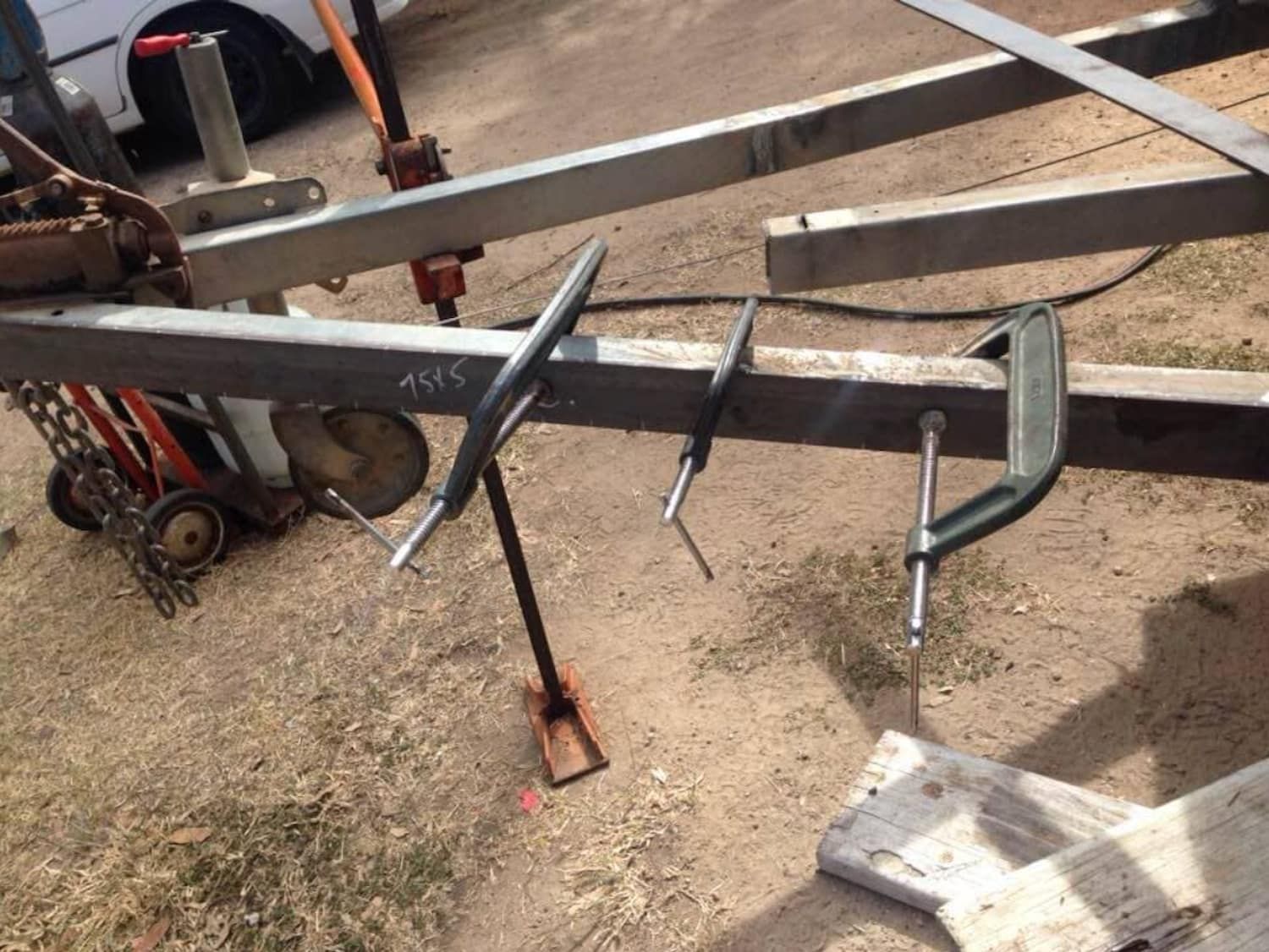 A Couple Of Clamps Are Sitting On A Piece Of Metal — Bohle Welding & Trailer Repairs In Bohle, QLD